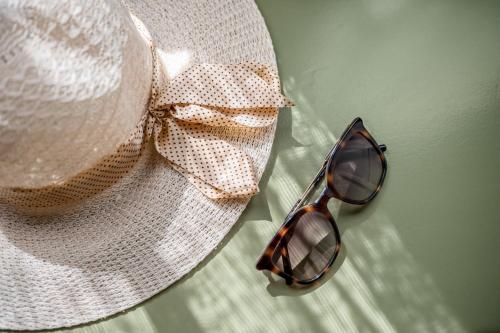 a pair of sunglasses and a hat with a bow at Terra Dei Limoni in Noto Marina