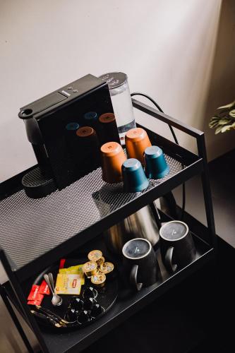 a black shelf with cups and other items on it at Burgstraat 8 in Ghent
