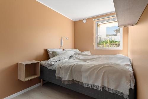 ein kleines Schlafzimmer mit einem Bett mit Fenster in der Unterkunft Northstay - Tromsø Urban Retreat - Free Parking, Brand New & Modern in Tromsø
