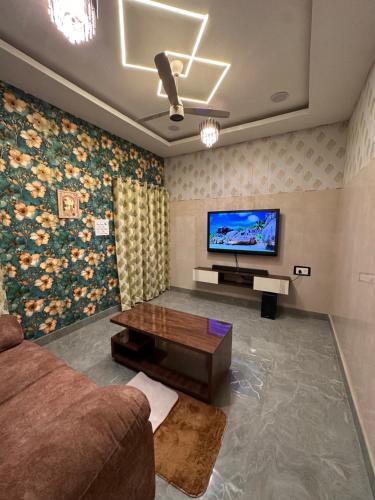 een woonkamer met een bank en een flatscreen-tv bij Royal Heritage in Lucknow