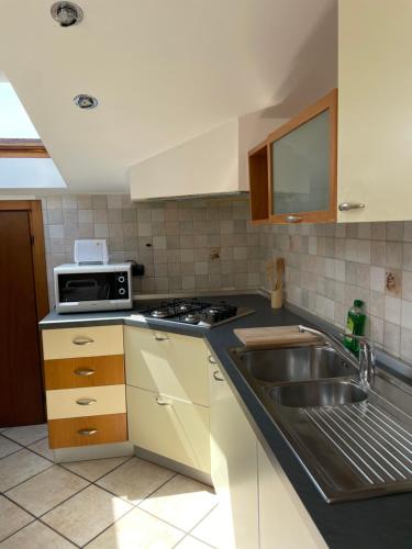 een keuken met een spoelbak en een magnetron bij Nico's apartment in Sirmione