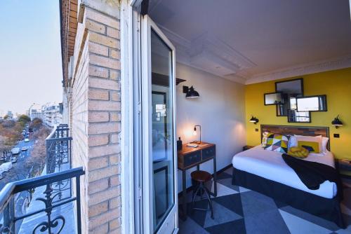 una camera da letto con un letto e un balcone di Madrigal a Parigi