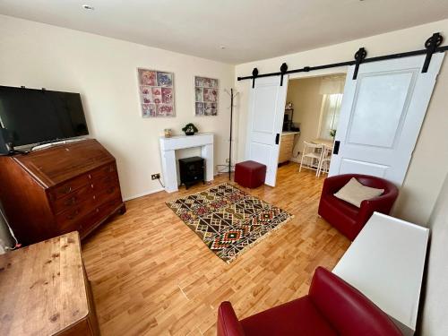 a living room with a television and a fireplace at The Shaw House, 1 in Knutsford