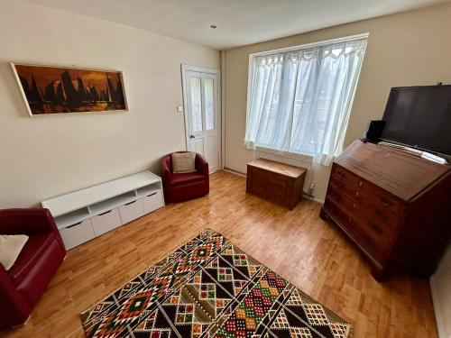 a living room with a couch and a tv at The Shaw House, 1 in Knutsford