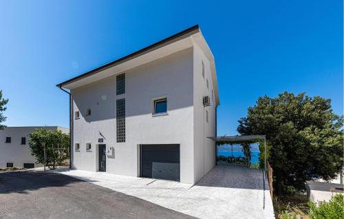 a large white building with a large garage at 2 Bedroom Stunning Apartment In Stanici in Stanići