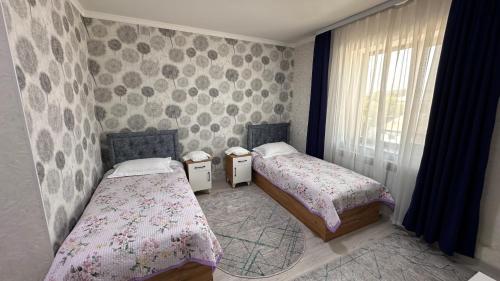 a bedroom with two beds and a window at УЮТ отель и хостел in Jalal-Abad