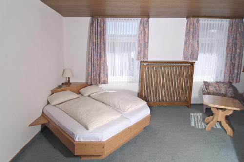 a bedroom with a bed and a chair and a window at Action Forest Hotel - Kletterwald - Lasertag - nähe Badeparadies in Titisee-Neustadt
