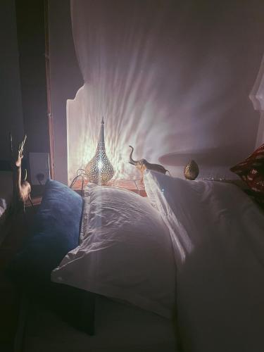 a bedroom with a bed with a white wall at Riad Bab Mahrouk in Chefchaouene