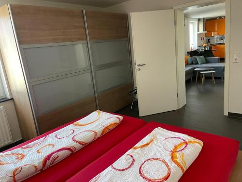 a bedroom with a red bed with a sliding door at Ferienhaus Haus Auenland in Nohfelden