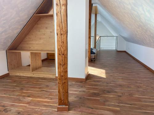 an attic room with a staircase with wooden floors at Ferienhaus Haus Auenland in Nohfelden