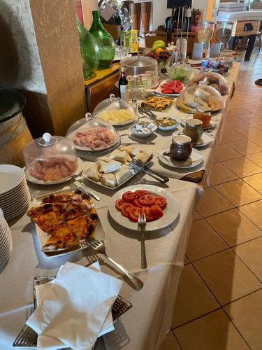 una linea a buffet con molti piatti di cibo sopra di Hotel Aurora a Marina di Cecina