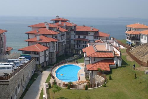 a group of houses with a swimming pool and the ocean at Etara 1 Apartment Complex in Sveti Vlas
