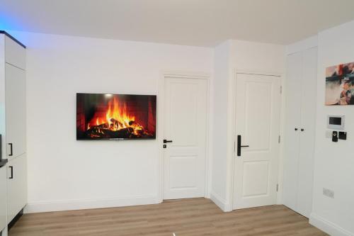 a white room with a fire on the wall at Luxury 1 bed flat London in Mitcham