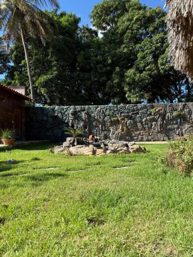 a stone wall with a statue in a yard at Pousada do Riacho in Barreirinhas