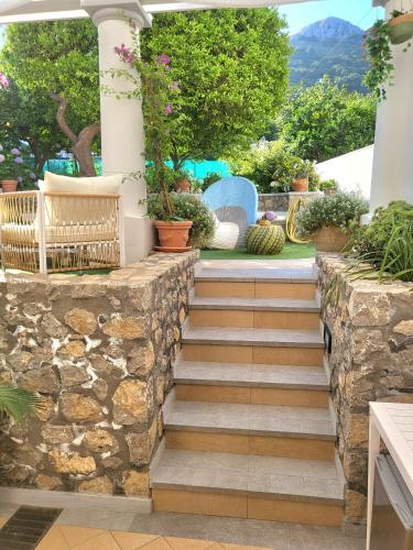 a patio with a stone wall and stairs at L'Agrumeto in Anacapri