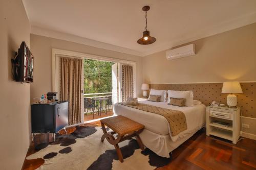 a bedroom with a large bed and a window at Secreto Boutique Hotel in Campos do Jordão