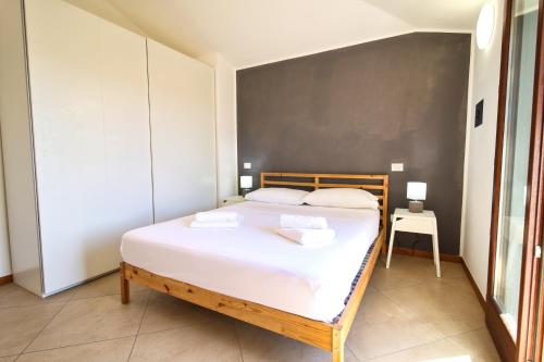 a bedroom with a bed with two towels on it at Appartamento La Conchiglia in Oristano