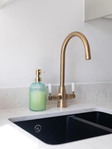 a kitchen sink with a green bottle next to a faucet at Flat 9- 1BR in Newport