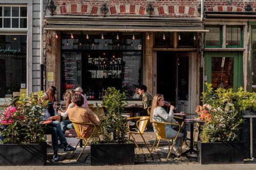 a group of people sitting at tables outside a restaurant at Burgstraat 8 in Ghent