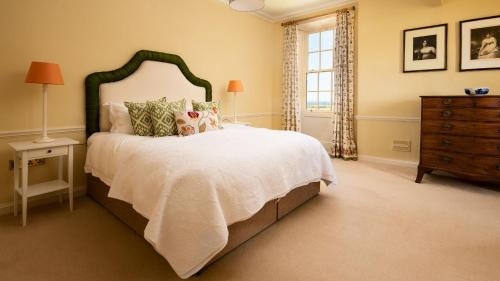 a bedroom with a large bed and a dresser at East House in Berwick-Upon-Tweed