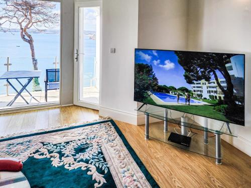 Una sala de estar con un televisor de pantalla plana grande. en Riviera Apartment, en Torquay