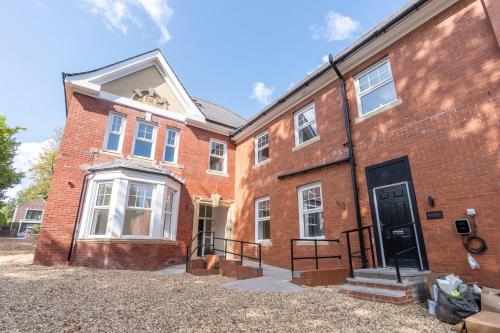 a red brick building with a black door at Chester House Apartment- 1BR in Newport