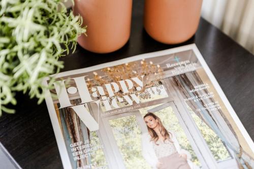 a magazine on a table with flowers and plants at Stijlvol Tiny House Zeeland - Centraal gelegen VP022 in Heinkensand