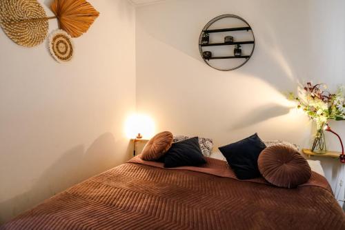 a bedroom with a bed with pillows on it at Stijlvol Tiny House Zeeland - Centraal gelegen VP022 in Heinkensand
