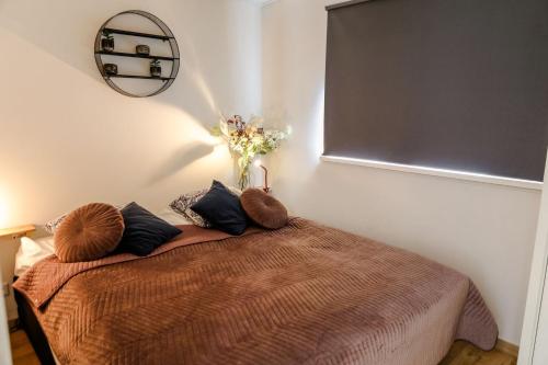 a bedroom with a bed with a vase of flowers on it at Stijlvol Tiny House Zeeland - Centraal gelegen VP022 in Heinkensand