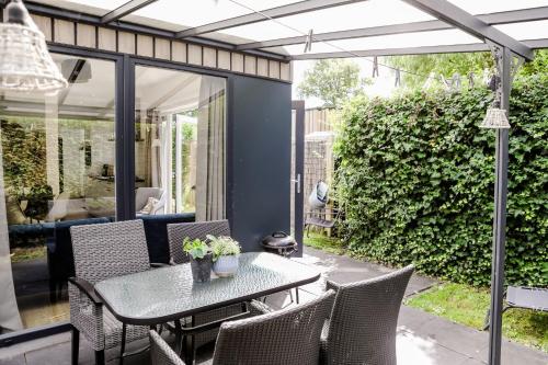 a patio with a table and chairs on a patio at Stijlvol Tiny House Zeeland - Centraal gelegen VP022 in Heinkensand