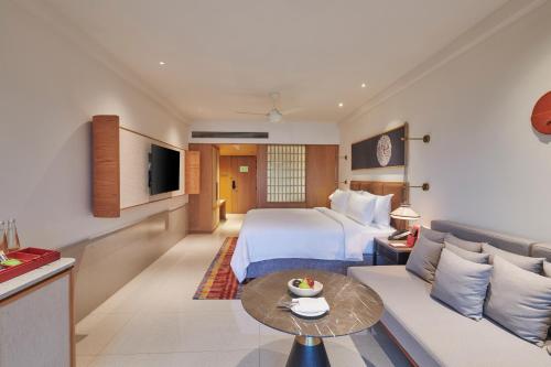 a hotel room with a bed and a couch at The Dukes Retreat Khandala in Lonavala