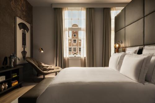 a bedroom with a large white bed and a window at Rosewood Amsterdam in Amsterdam