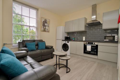 a living room with a couch and a kitchen at Warwick Row Apartments Coventry City Centre - Flat 1 in Coventry