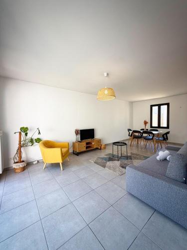 un soggiorno con un divano e un tavolo di Maison du bonheur ad Aytré