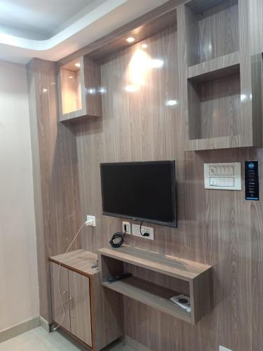 a room with a television on a wooden wall at Hotel Sana a family-friendly guest house in Kolkata