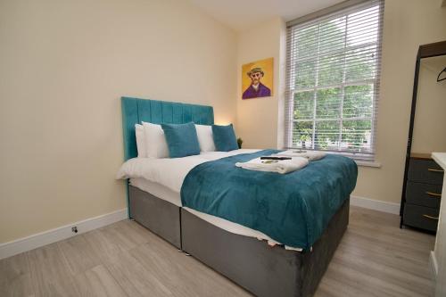 a bedroom with a large bed with a blue headboard at Warwick Row Apartments Coventry City Centre - Flat 1 in Coventry