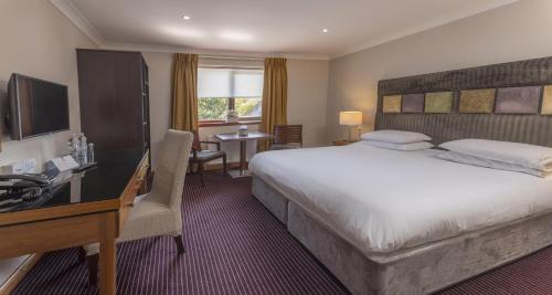 a hotel room with a large bed and a desk at Best Western The Hilcroft Hotel West Lothian in Whitburn
