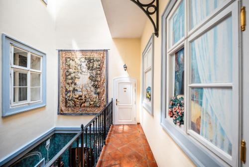 a hallway with a tapestry on the wall and a door at Nosticova Heritage in Prague