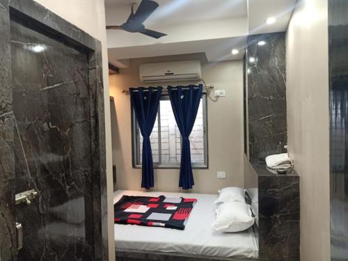 a small room with a bed and a window at Hotel Sana a family-friendly guest house in Kolkata