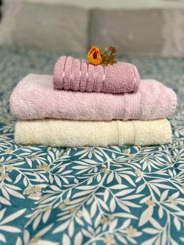 a pile of towels sitting on top of a bed at Pousada e Hotel Italian Garden House in Campo Grande
