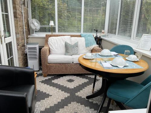 a living room with a table and a couch at The Snug @ Corry Cottage in Haltwhistle