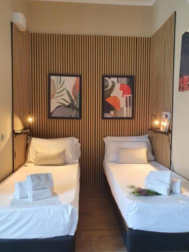 two beds in a room with striped walls at BNBOOK - Green Zone Studio in Paderno Dugnano