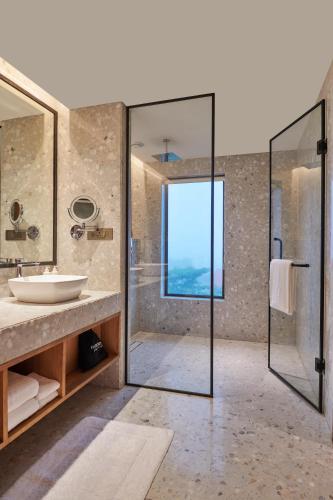 a bathroom with a glass shower and a sink at The Dukes Retreat Khandala in Lonavala