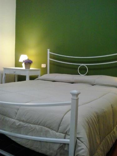 1 dormitorio con cama blanca y pared verde en Agriturismo Camera dei ladri, en Marsiliana