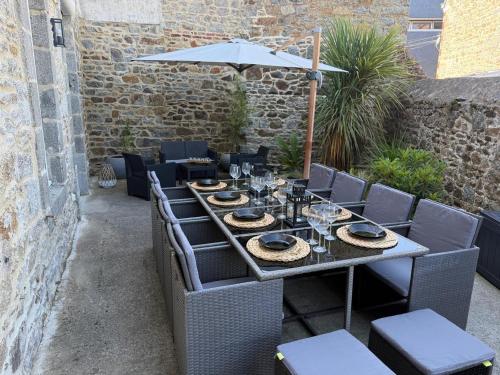 une table avec des chaises et un parasol sur une terrasse dans l'établissement L'elegante - Proche centre, à Saint-Brieuc