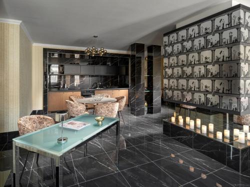 a lobby with a table and chairs and a wall of vases at Mamaison Hotel Chain Bridge Budapest in Budapest