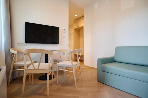 a room with a table and chairs and a tv at Toplice Family Inn - Terme Čatež in Čatež ob Savi