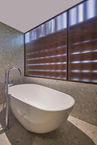 a bath tub in a bathroom with a window at The Dukes Retreat Khandala in Lonavala