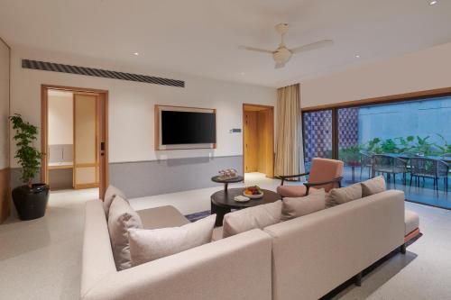 a living room with a couch and a tv at The Dukes Retreat Khandala in Lonavala