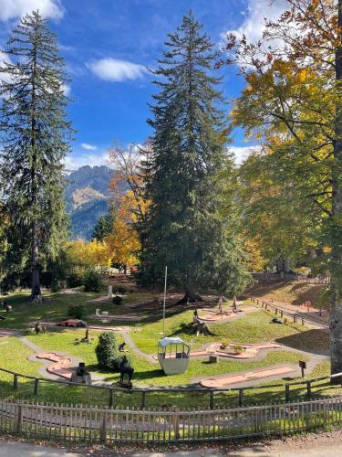 a park with a bench and trees and a fence at Chalet Tendre est la Nuit à Gryon - 6 personnes, belle vue, tout confort in Gryon